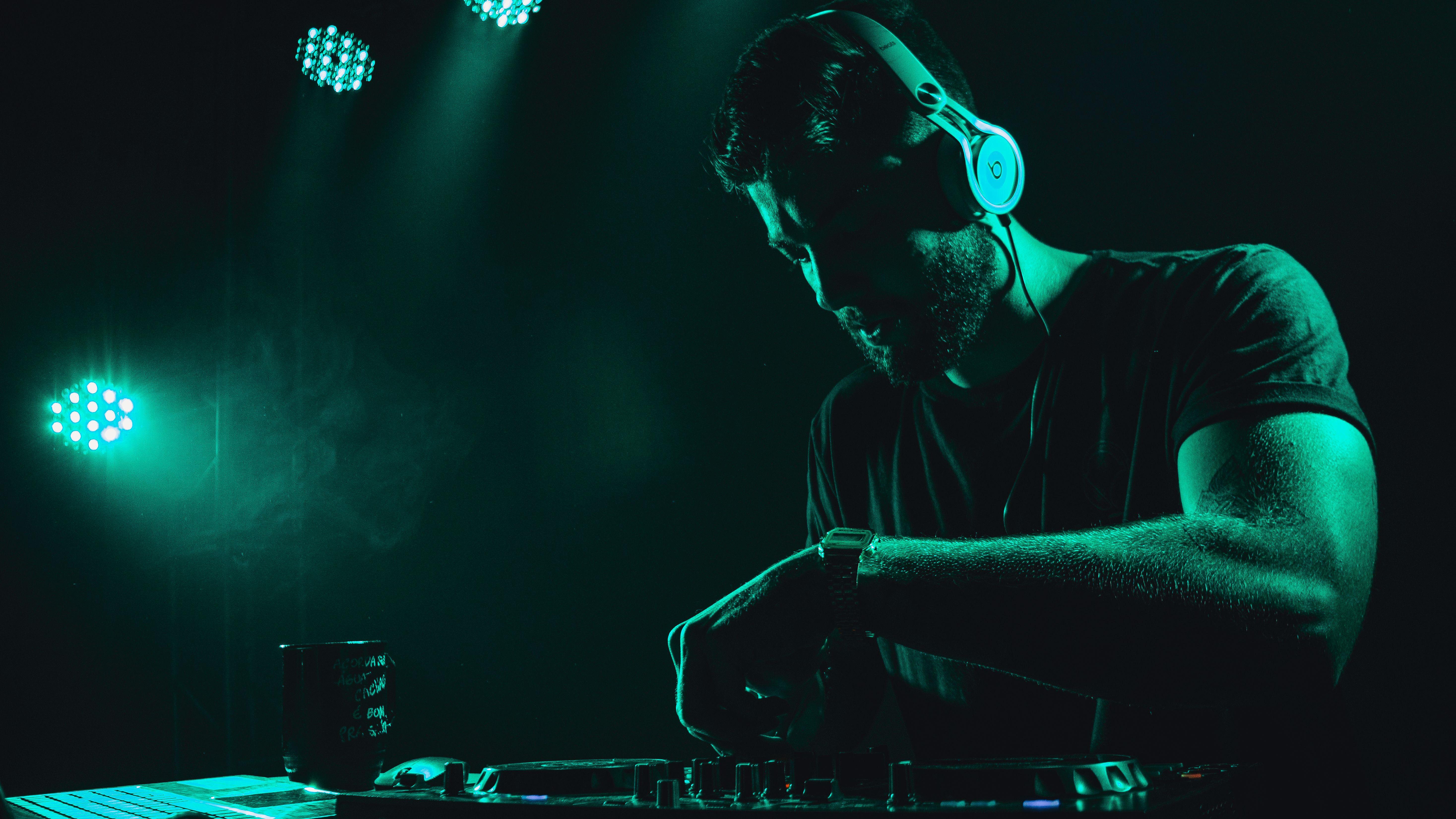 DJ mixes music live on stage with vibrant lighting creating an energetic atmosphere.