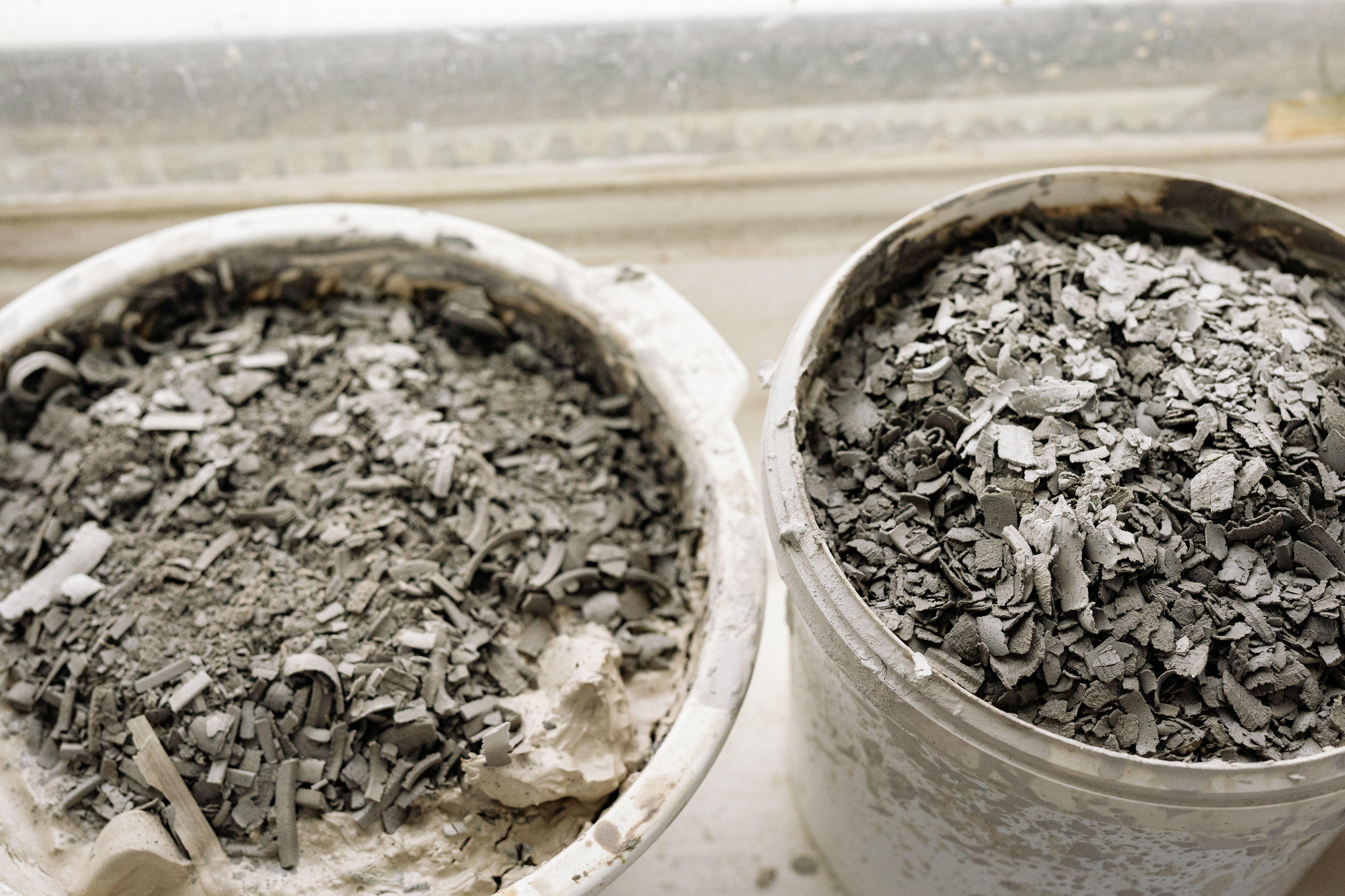 Two buckets filled with ash and debris, possibly from construction or cleanup.