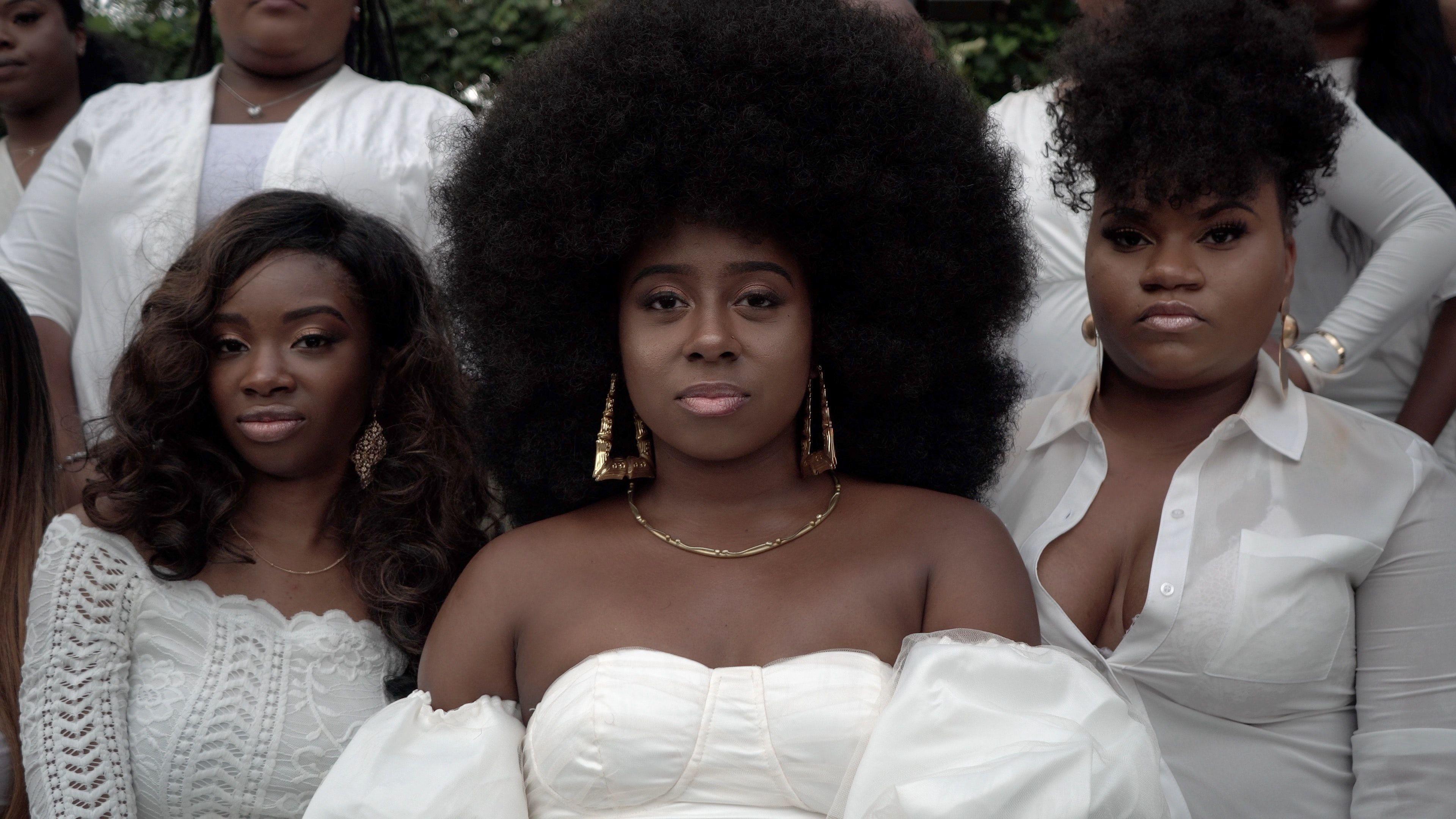 Stylish black women with afro hair posing confidently in elegant white outfits.
