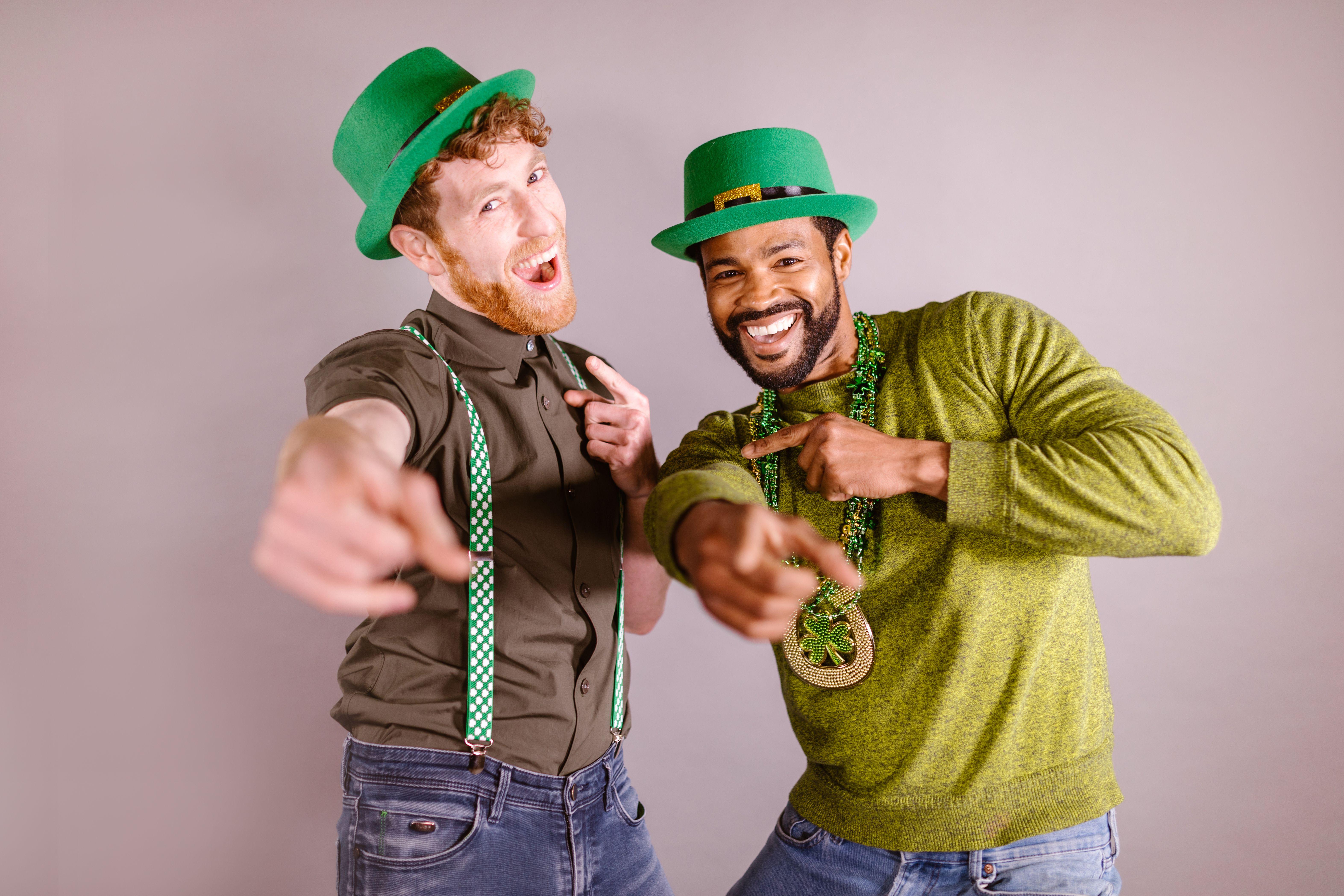Two friends celebrating St. Patrick's Day with green hats and accessories, enjoying a fun moment.