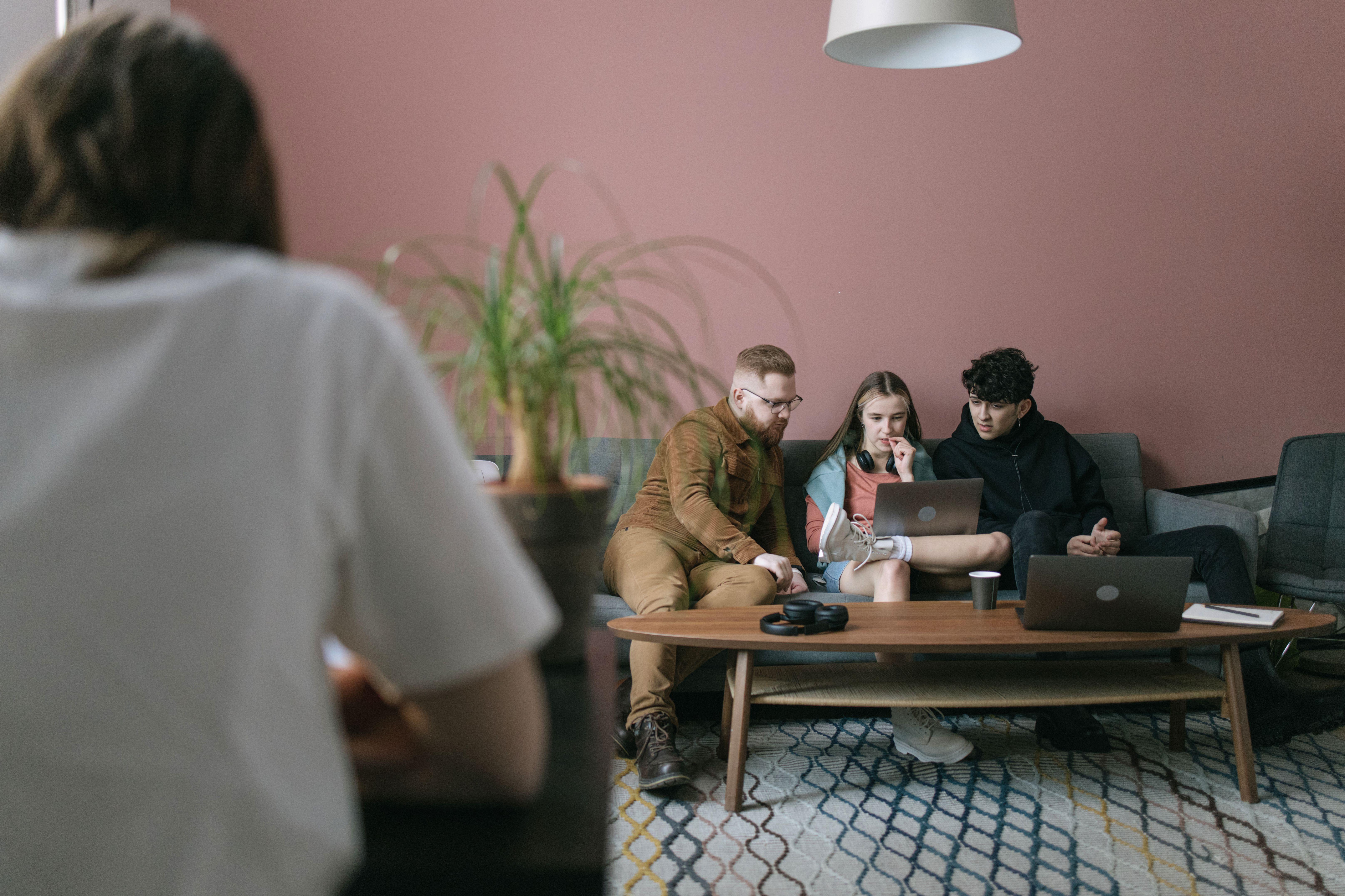 A diverse group of young professionals collaborating on a project in a contemporary office setting.