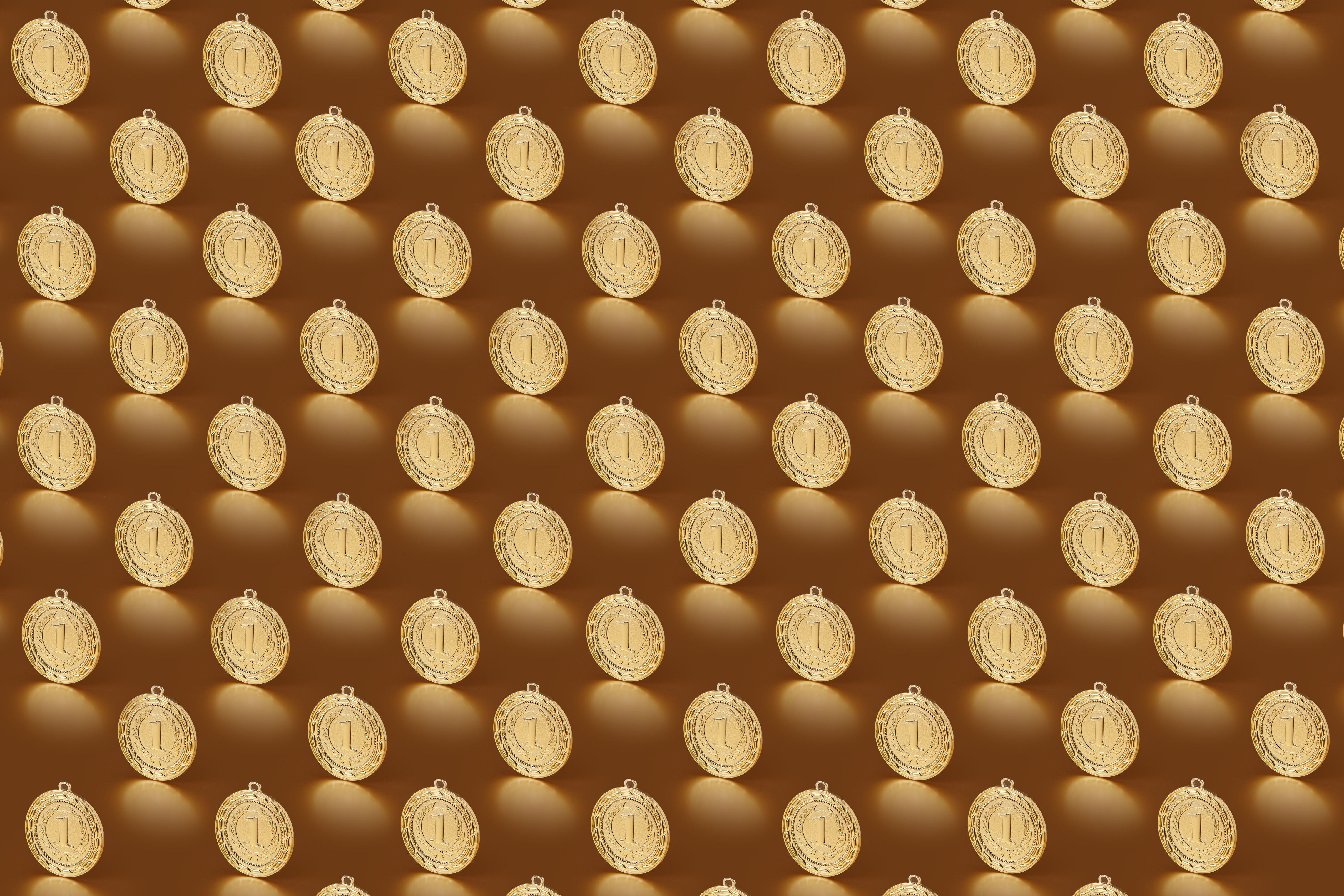 Multiple gold medals arranged in a repeating pattern on a brown backdrop.