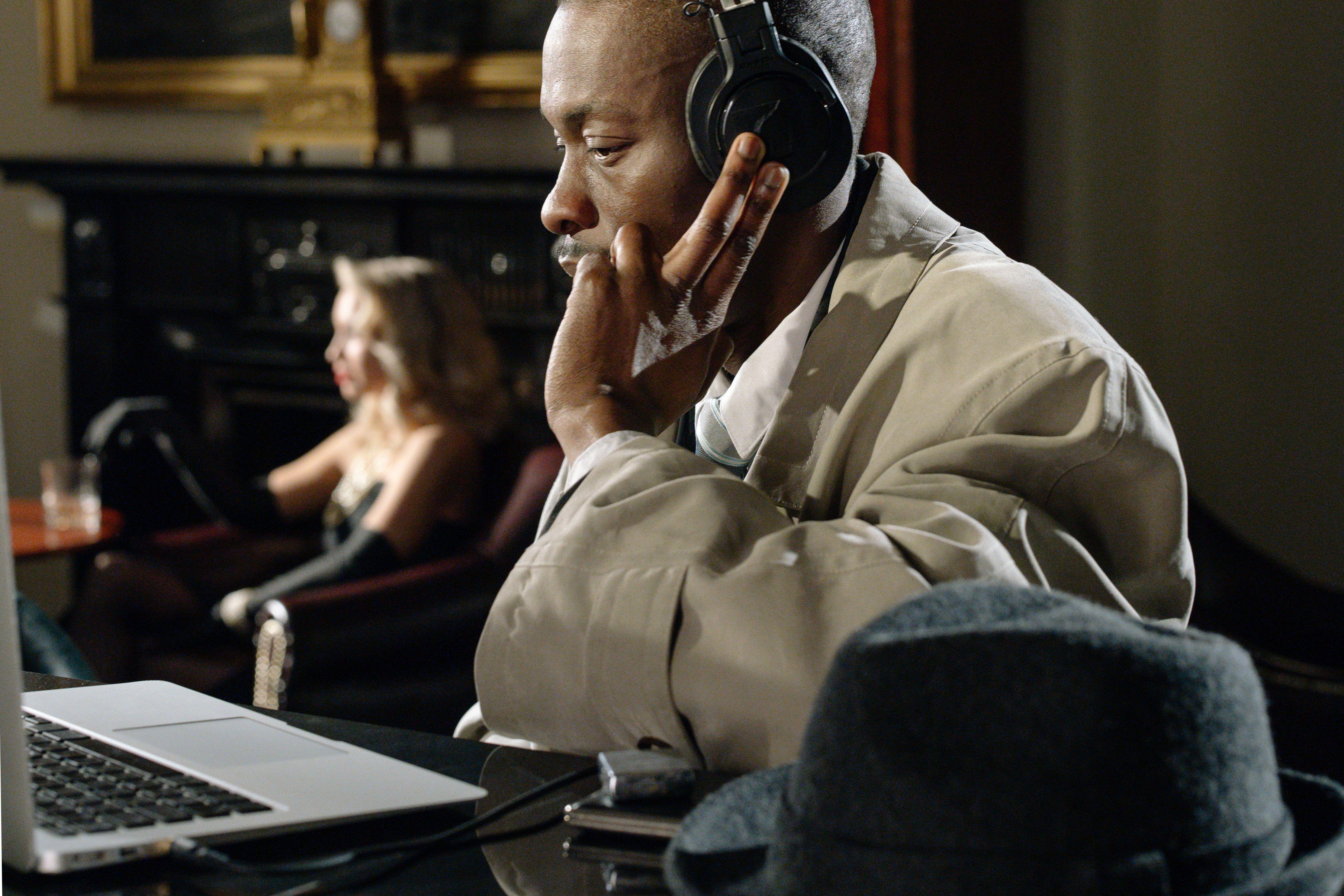 A focused detective listens intently through headphones, embodying the noir style.