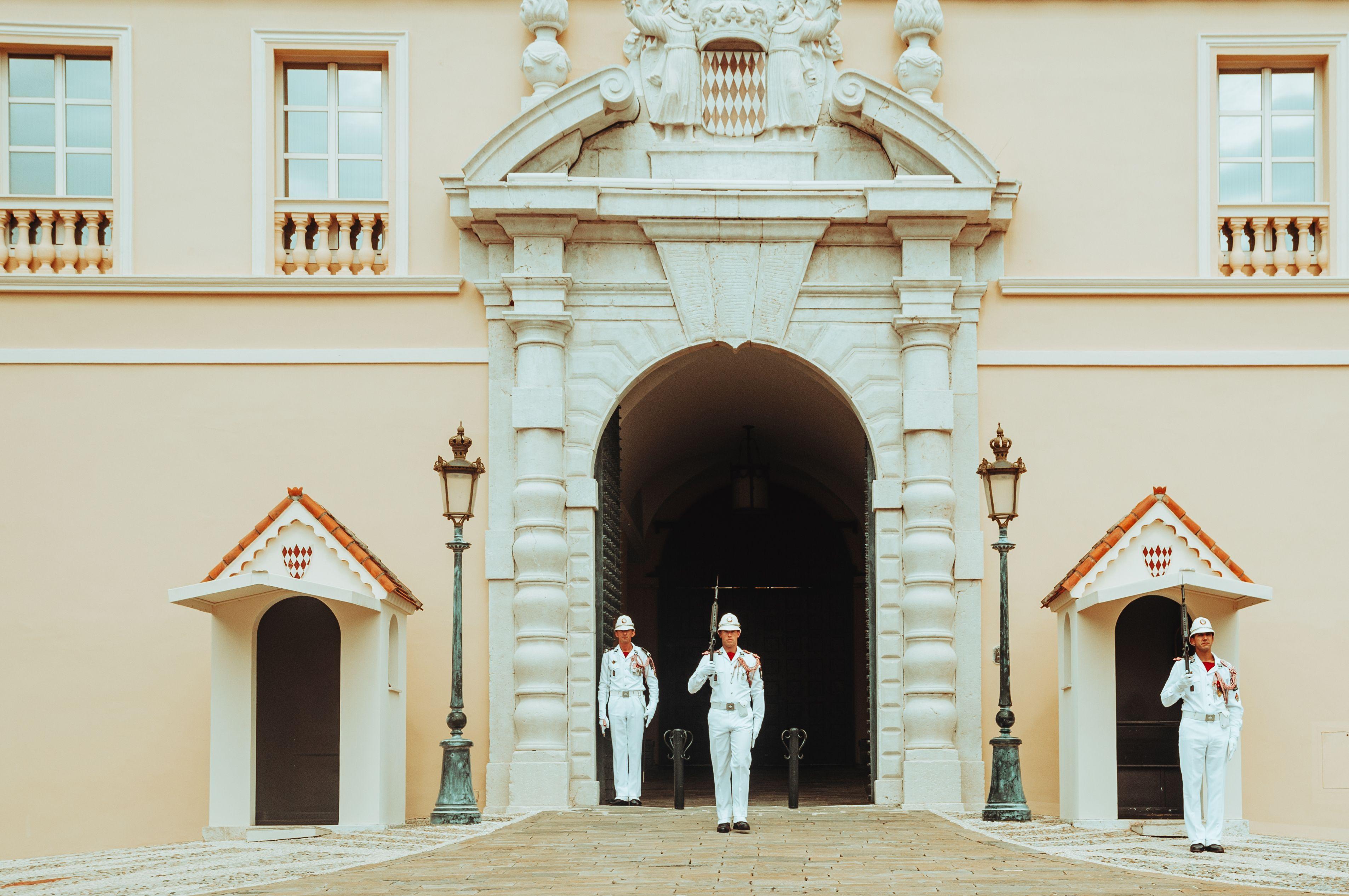 Guards standing at the entrance of the Prince's Palace, Monaco. Elegant architecture and ceremonial uniforms.