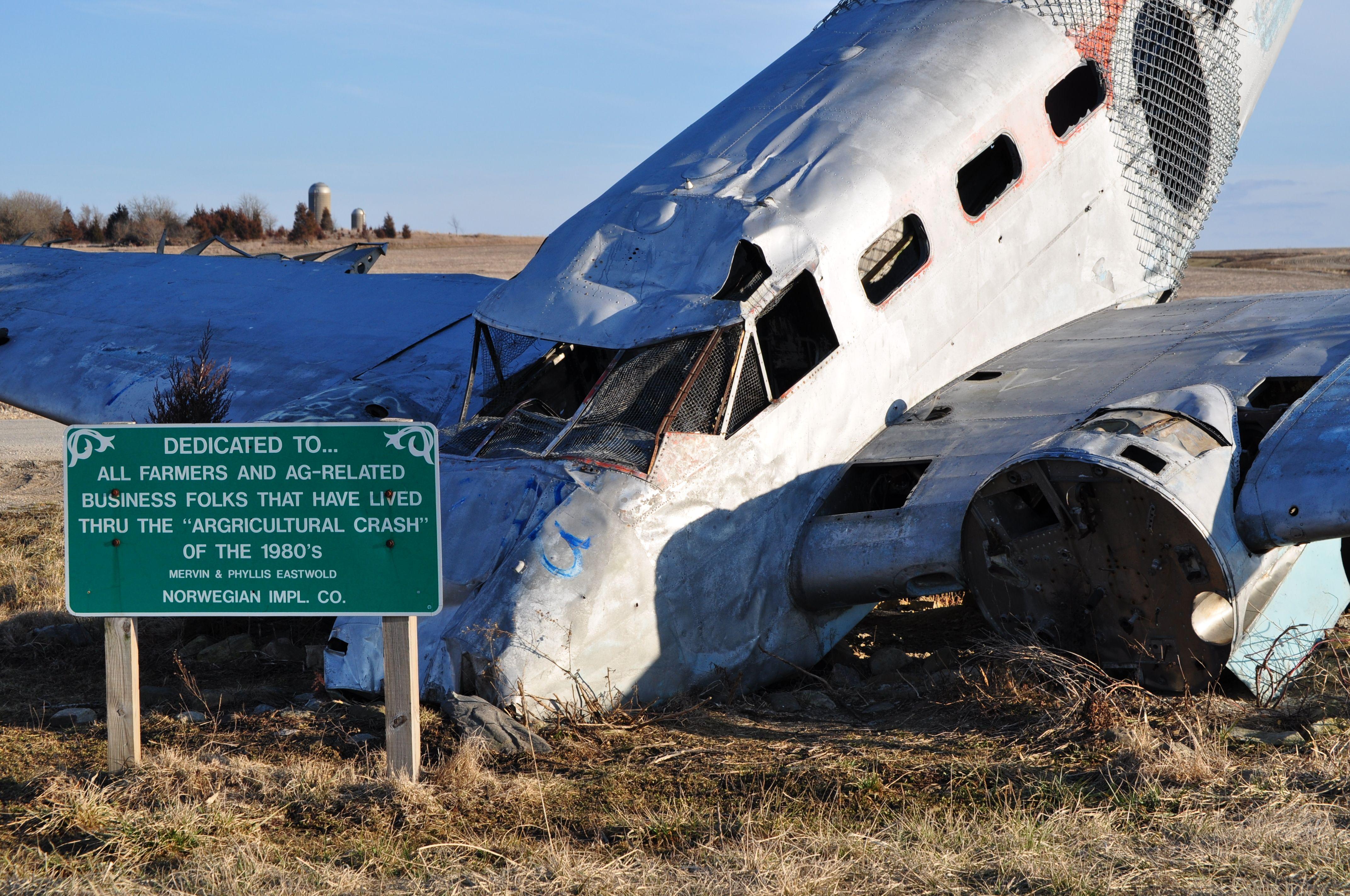 A wrecked airplane amid an open farmland, symbolizing the agricultural crash of the 1980s.