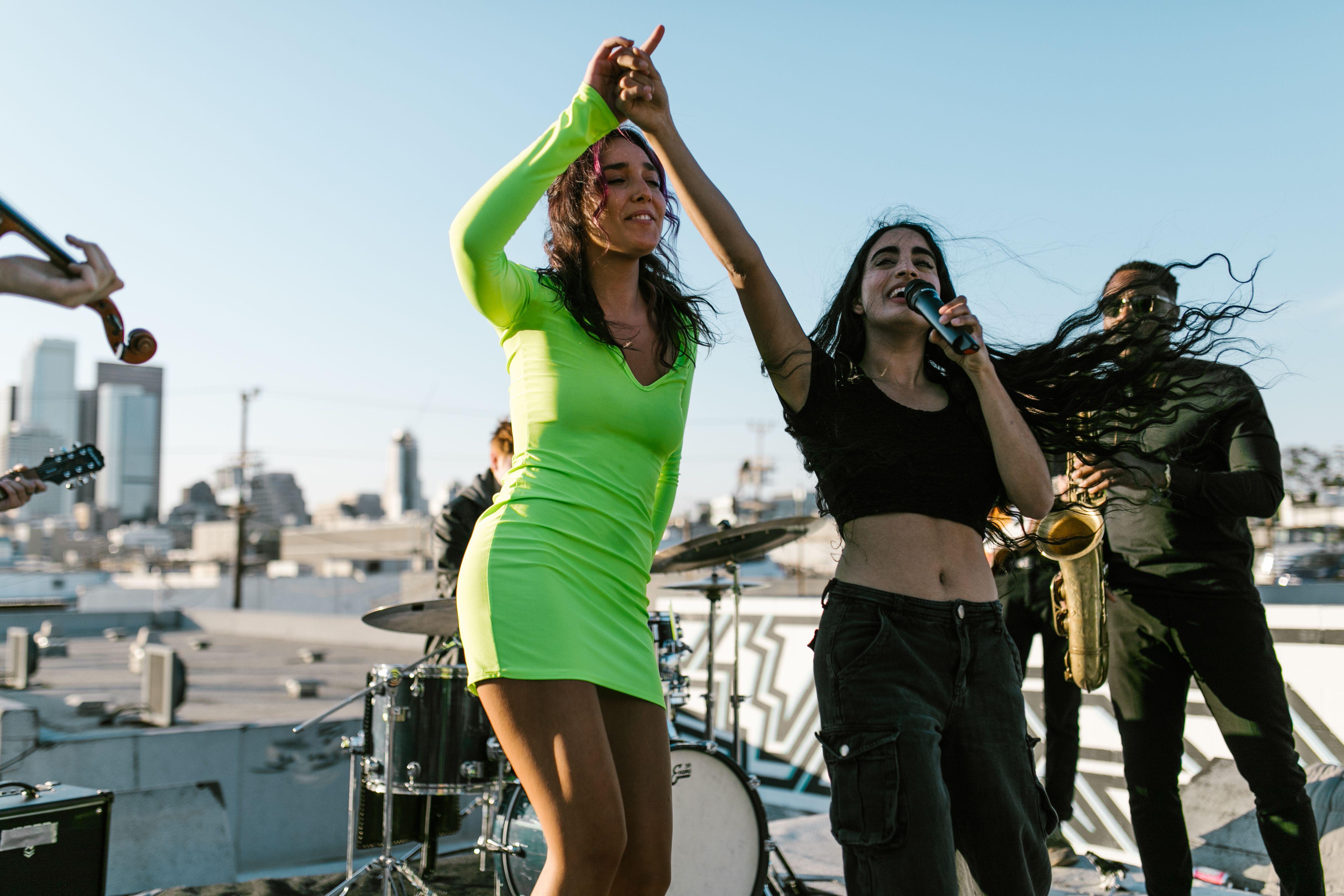 A vibrant rooftop band performance featuring singers, instruments, and a lively atmosphere.