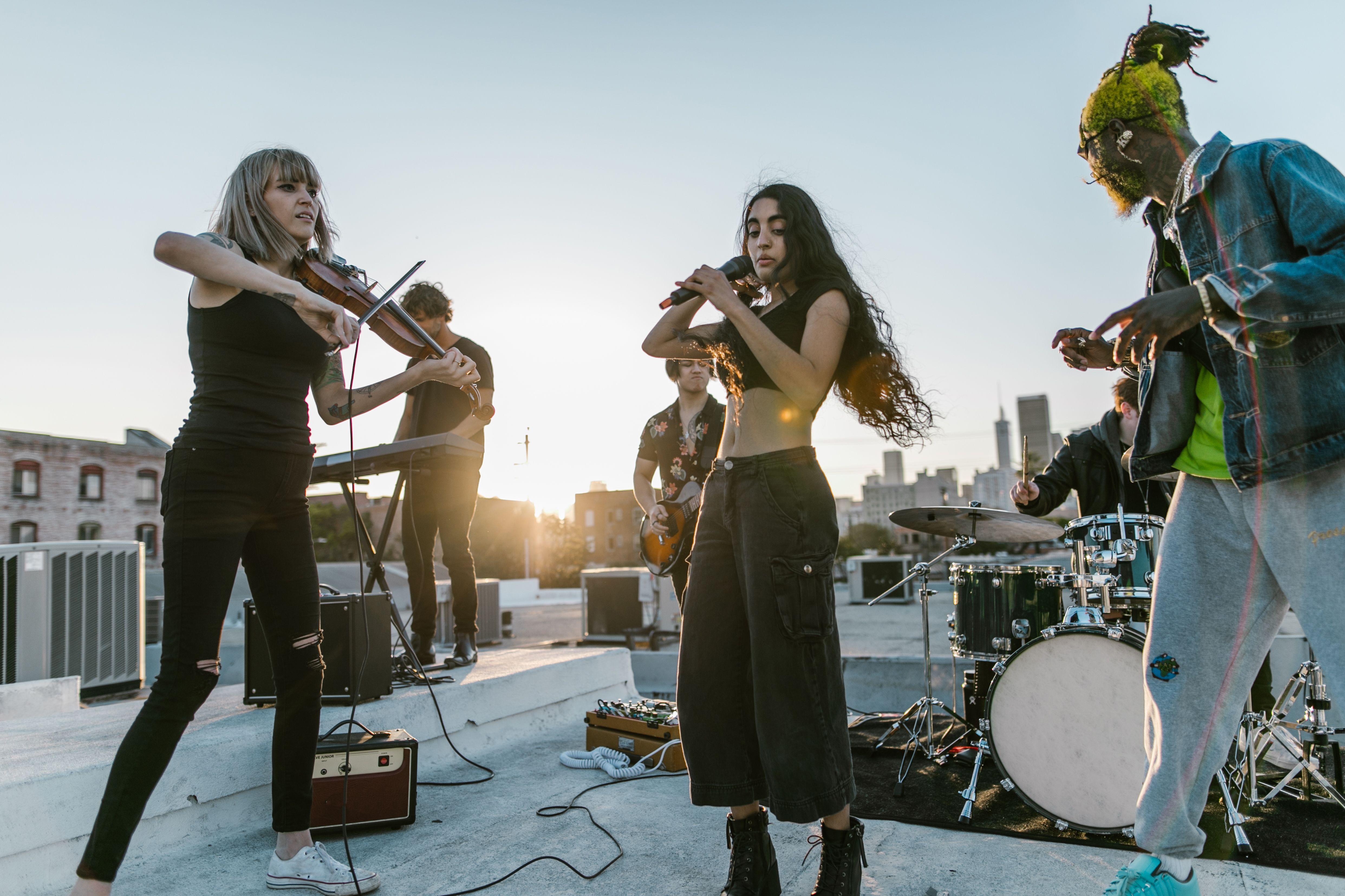 A lively band performs on a rooftop at sunset, capturing a vibrant musical atmosphere.
