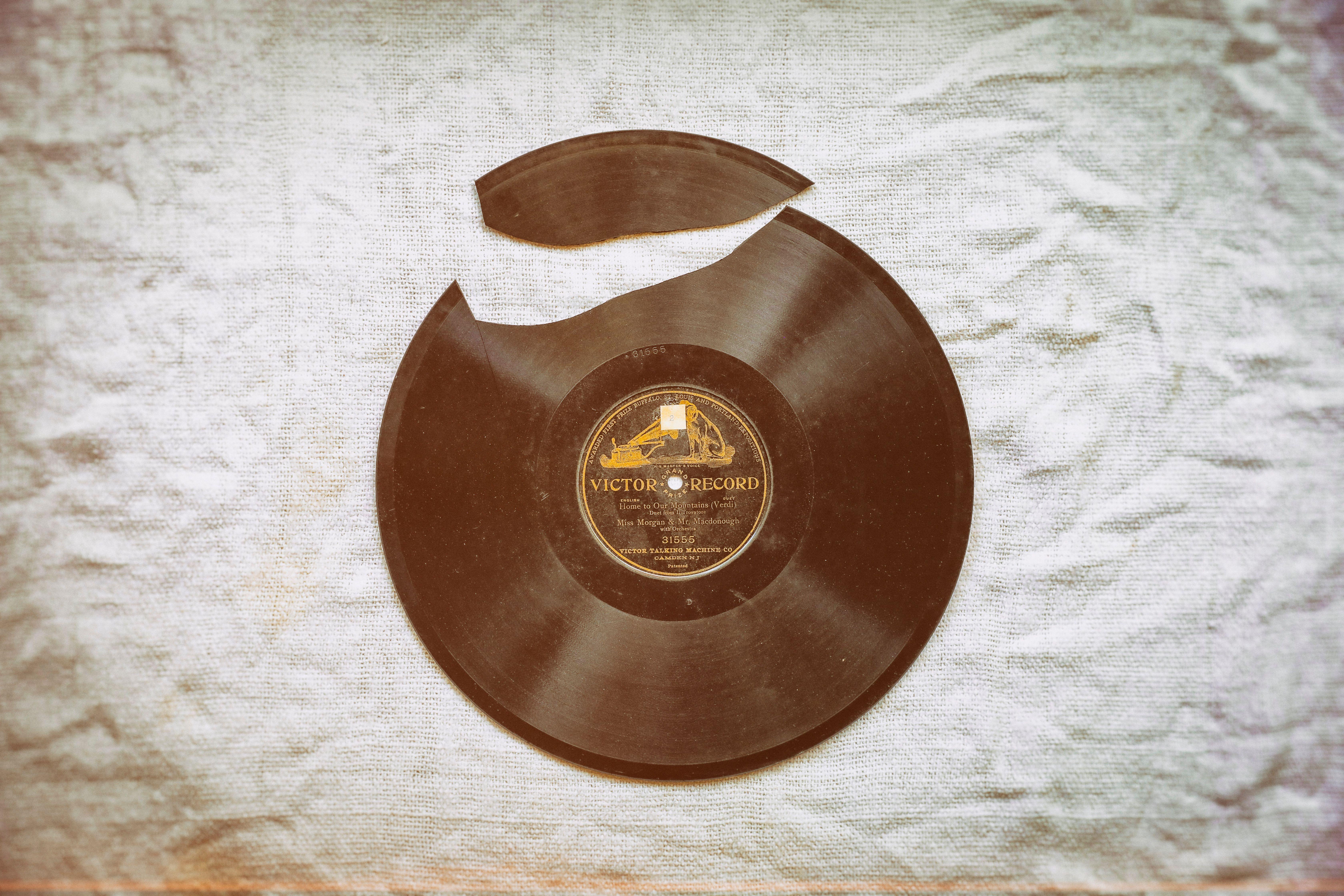 A close-up of a broken vintage vinyl record with nostalgic retro vibes on fabric.