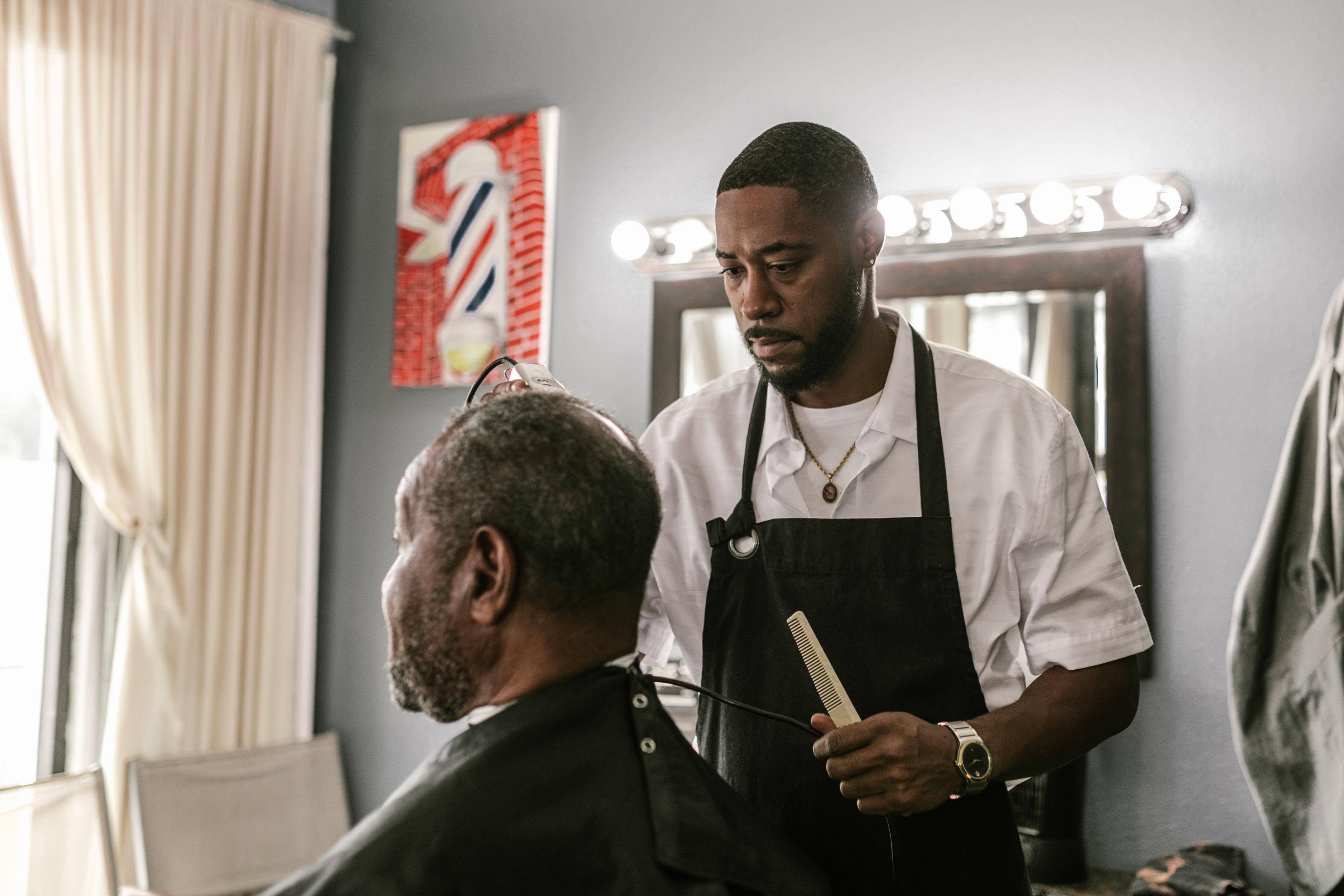 Barber in a modern salon skillfully styling a client's hair, capturing the essence of grooming.