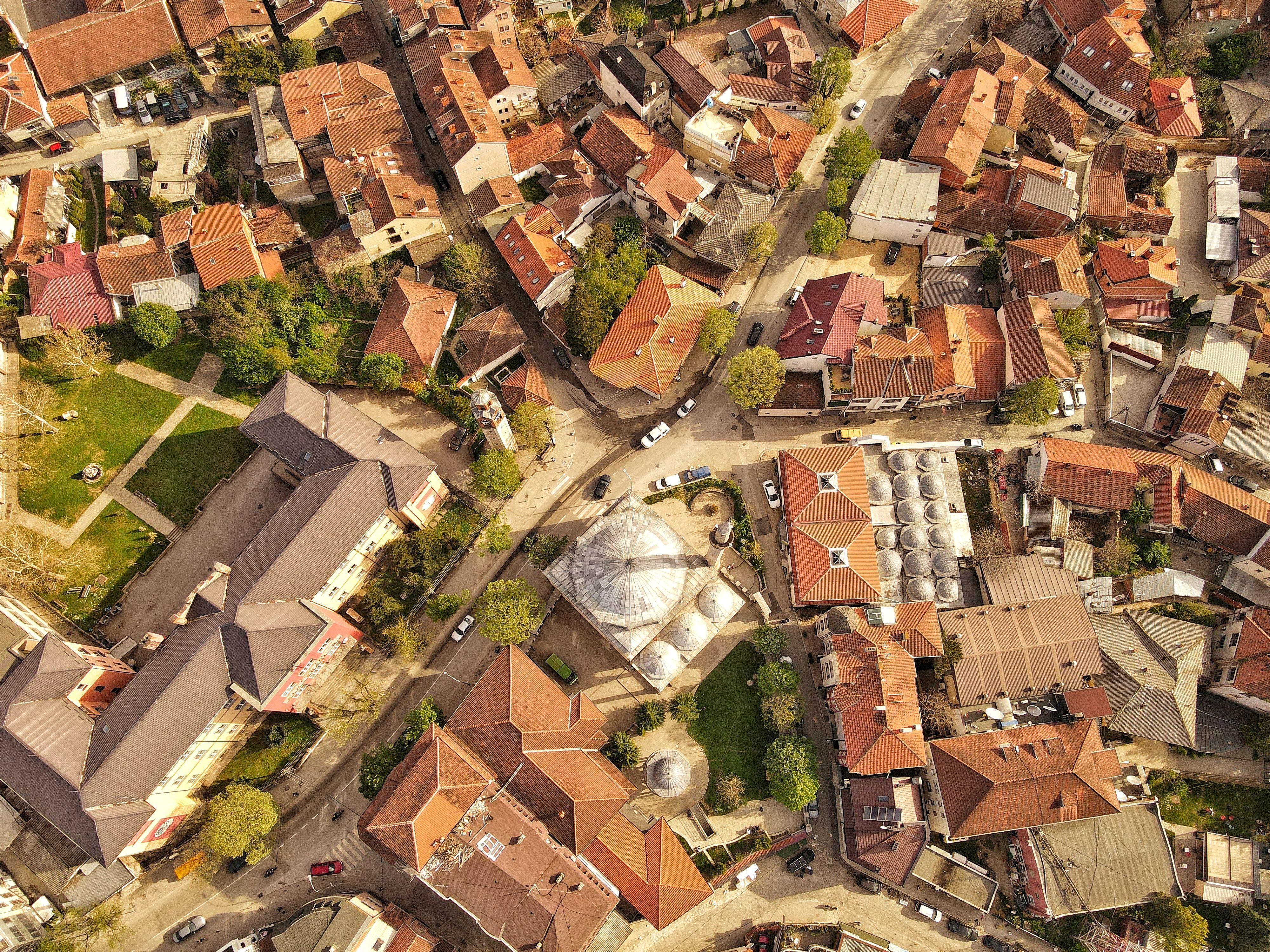 Drone shot of Prishtinë urban landscape with red roofs and unique architecture.