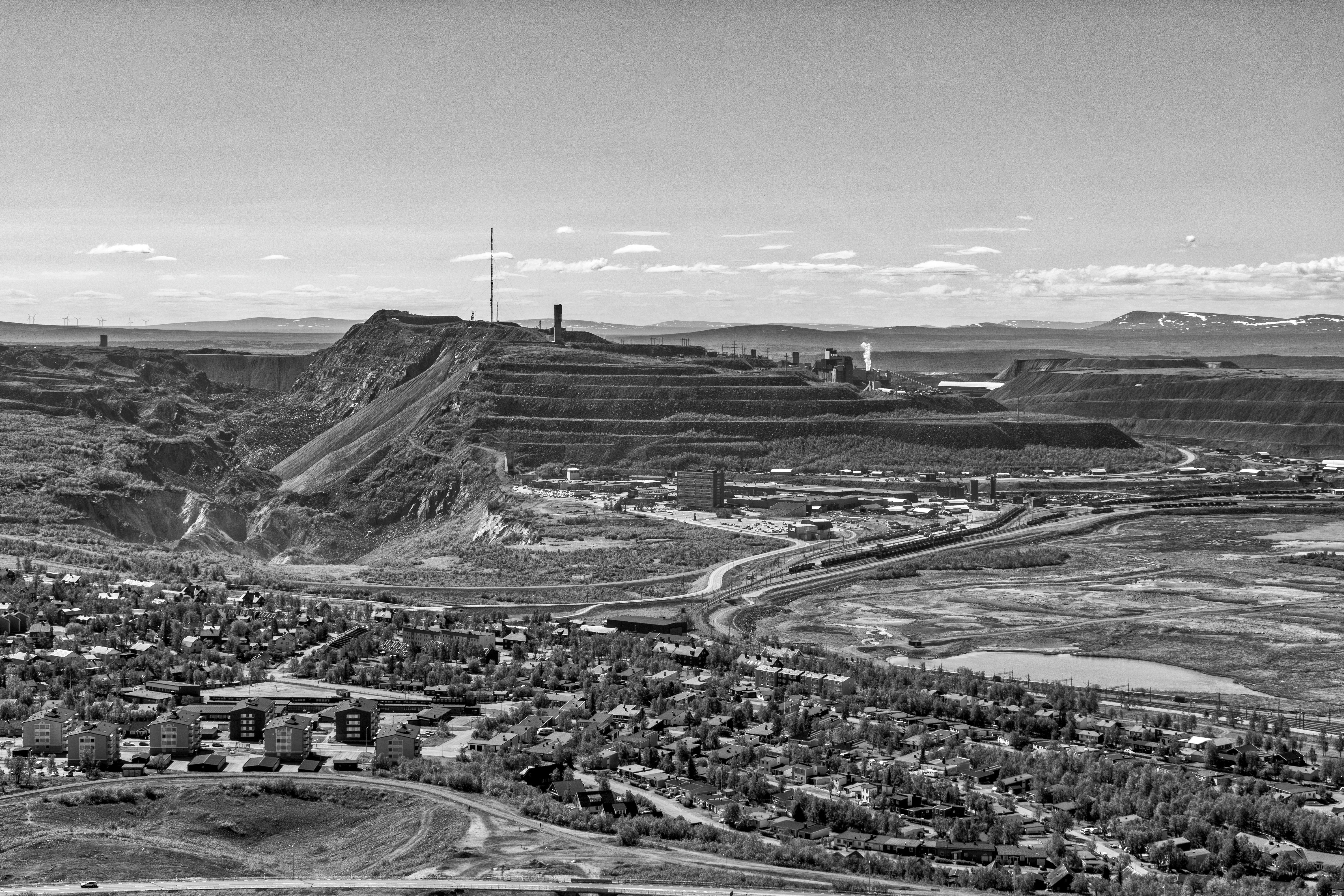 Monochrome aerial view of Kiruna mine, showcasing industrial and natural landscapes.
