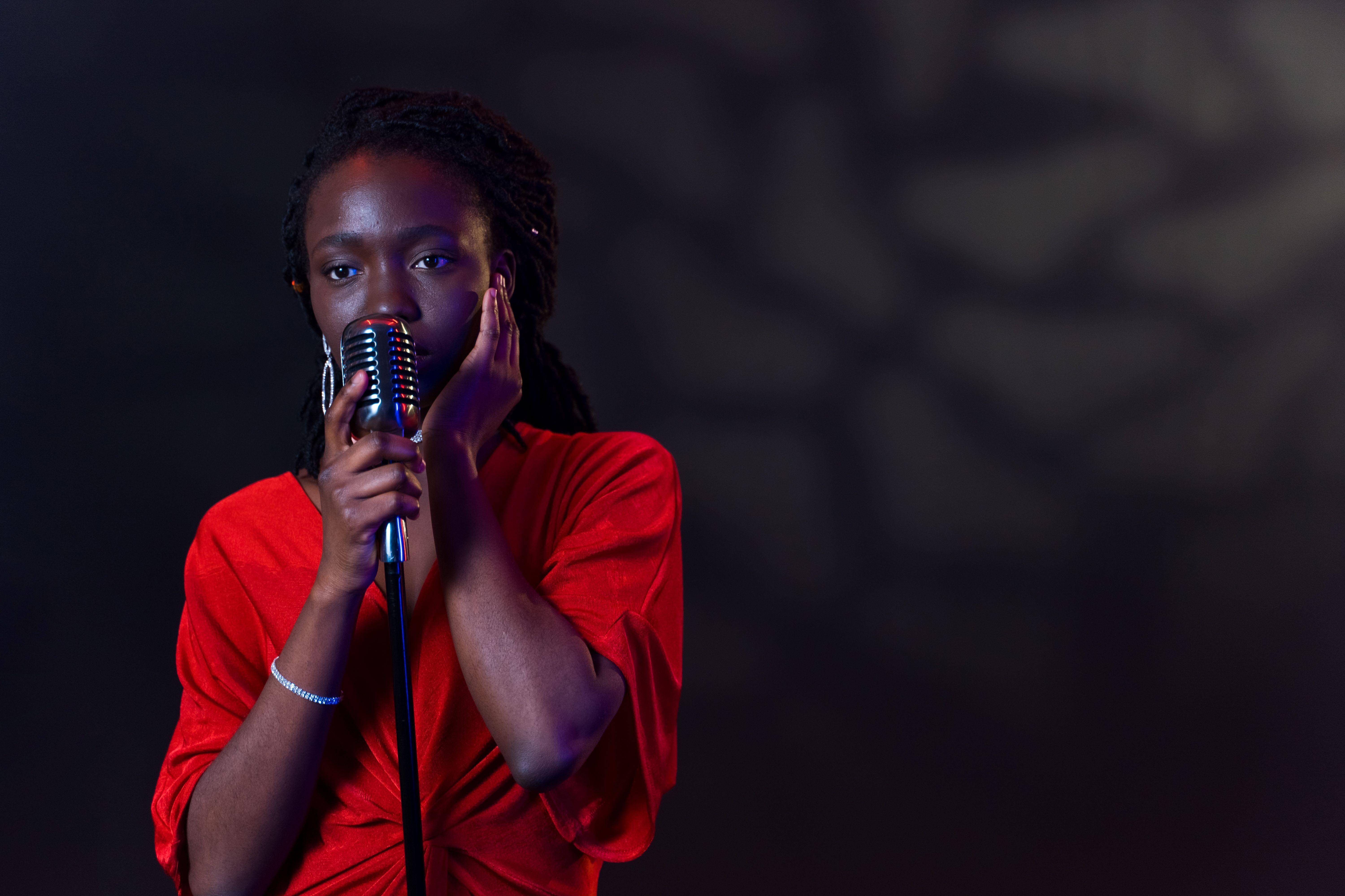 A captivating image of an African American woman singing passionately into a vintage microphone.