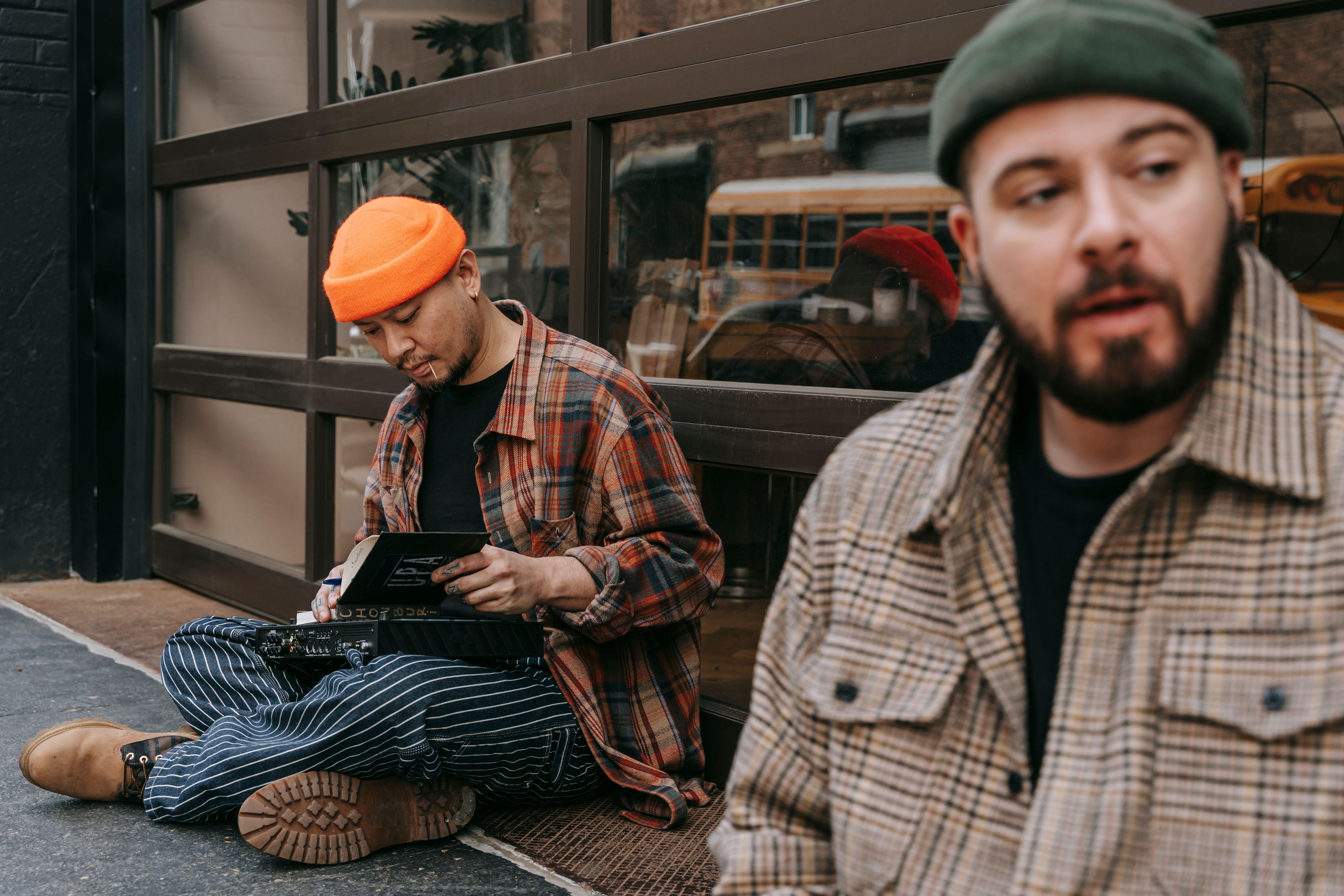 Two musicians composing on the street, wearing stylish clothes.
