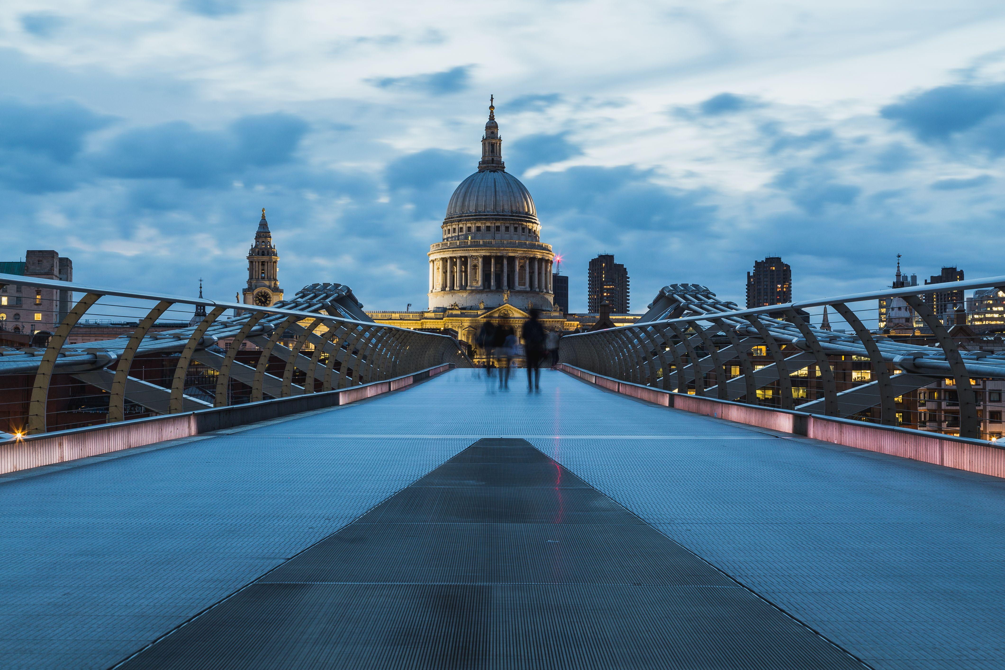 A striking shot of St Paul's Cathedral in London taken from Millennium Bridge at dusk, highlighting modern architecture.