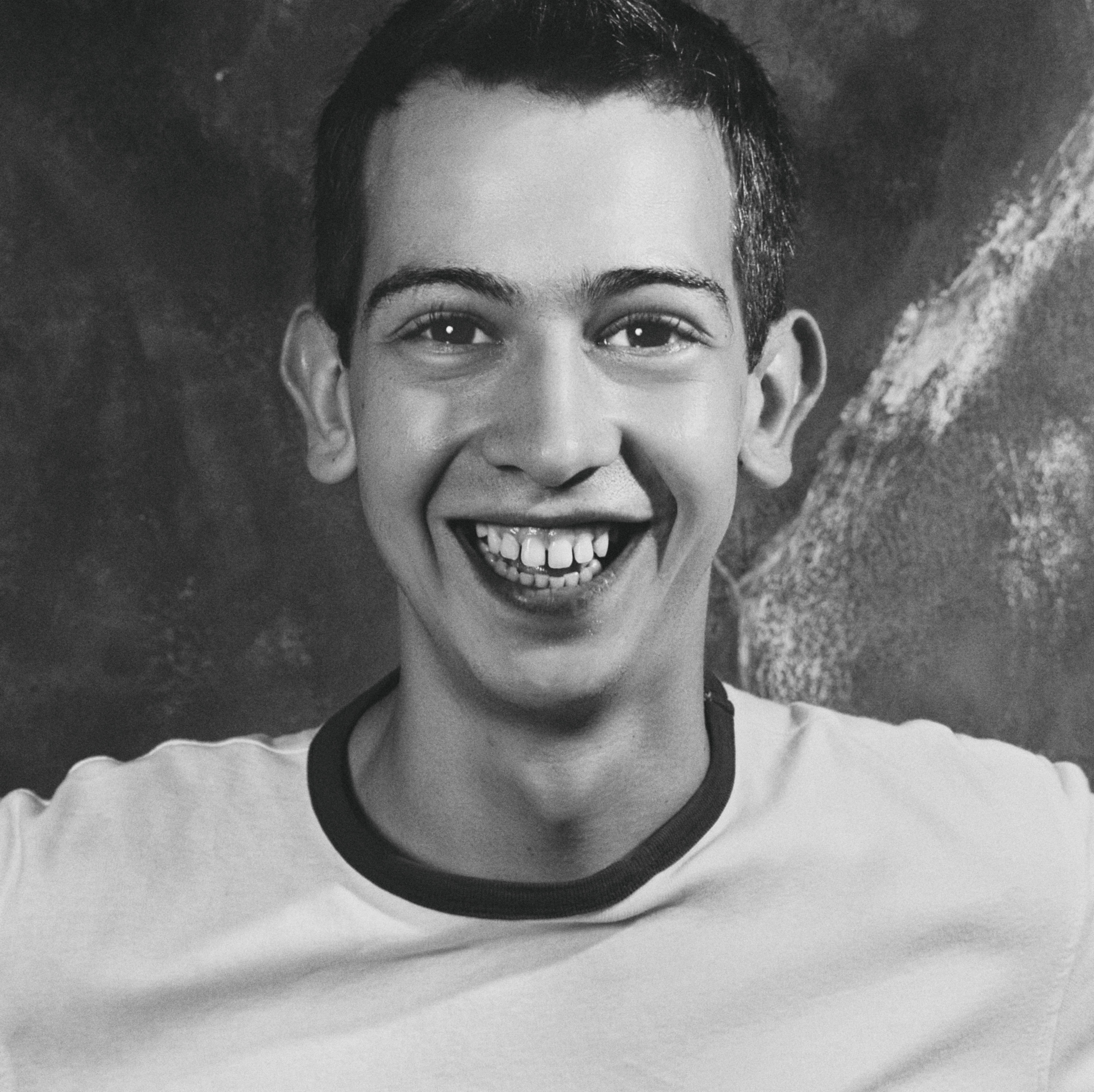 Energetic black and white portrait of a happy young man with a joyful smile.