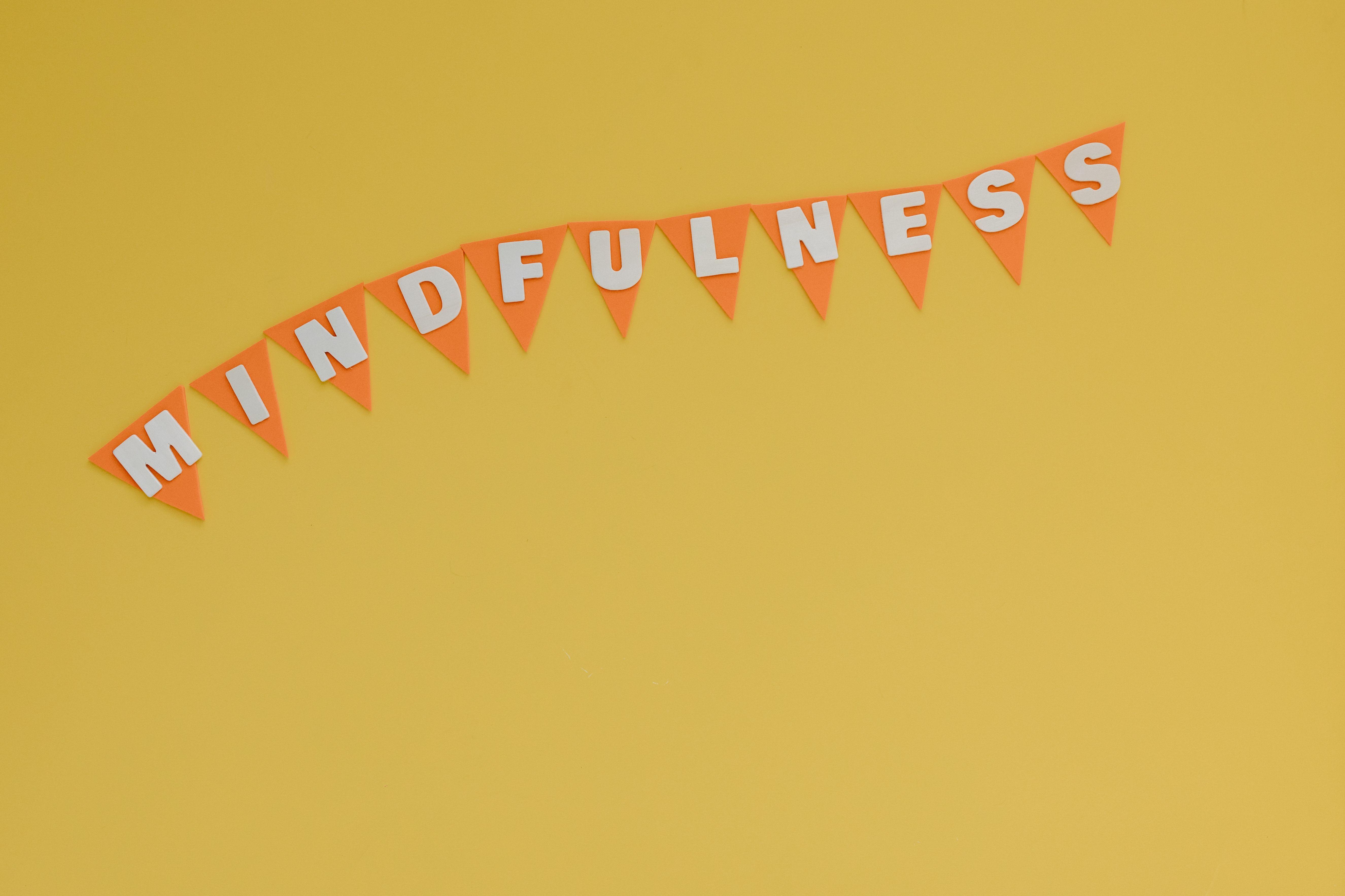 Banner with 'Mindfulness' on a bright yellow background, symbolizing calm and focus.