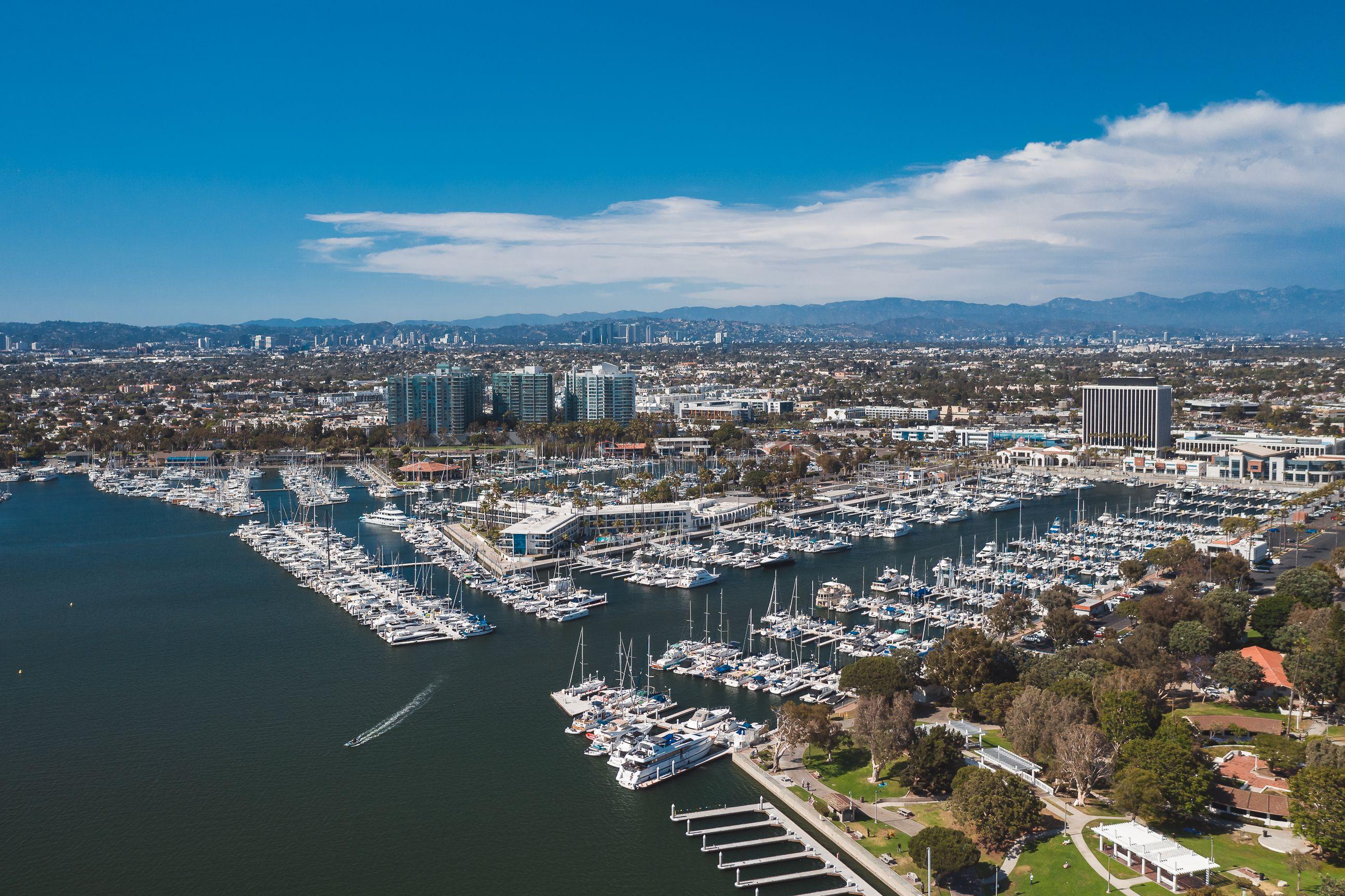 Stunning aerial photograph of Marina Del Rey showcasing boats and city skyline under a clear blue sky.