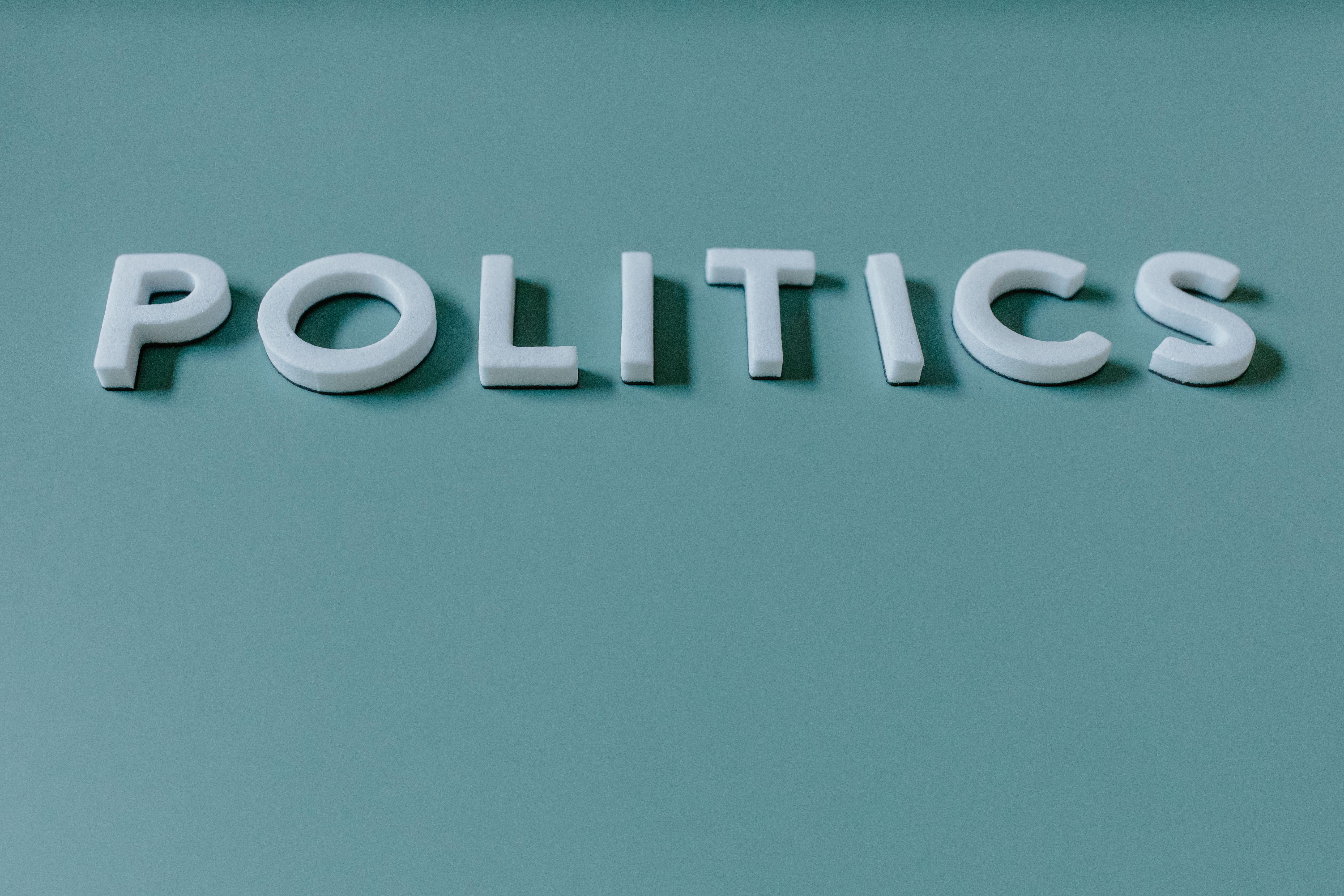 Close-up image of the word 'Politics' against a teal green background, highlighting political themes.