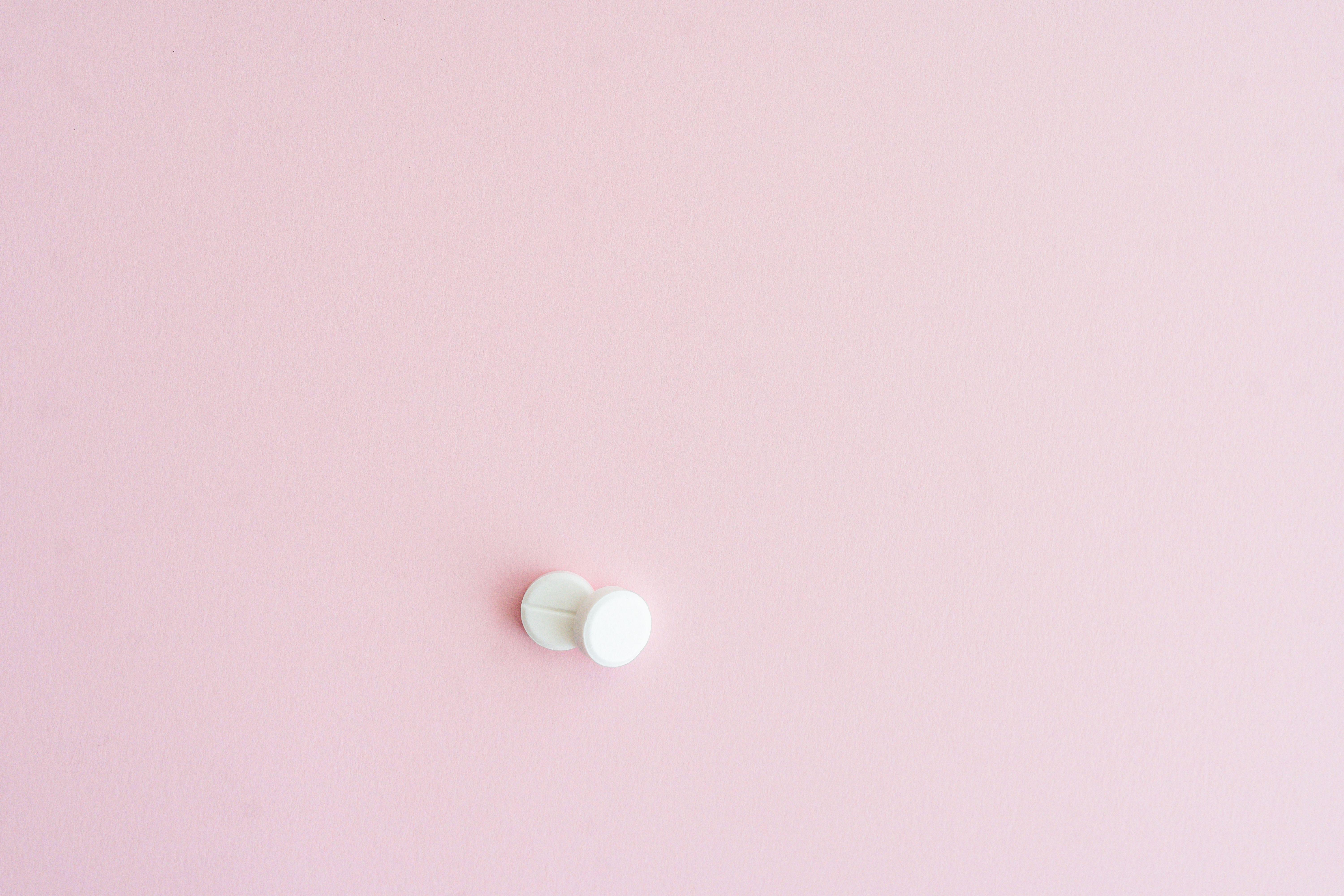 Two white tablets on a soft pink background, showcasing minimalist design.