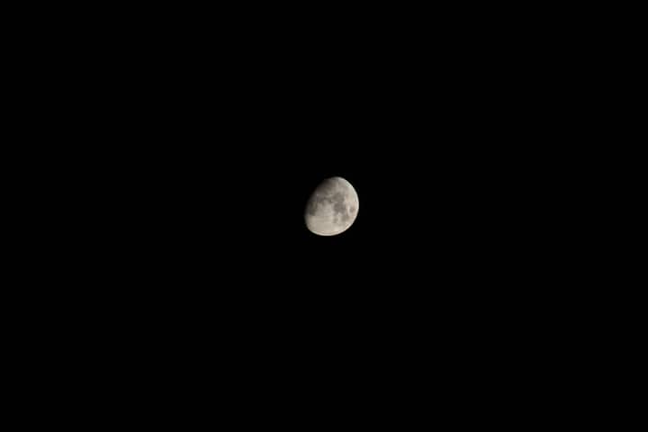 A stark image of a crescent moon set against a black night sky.