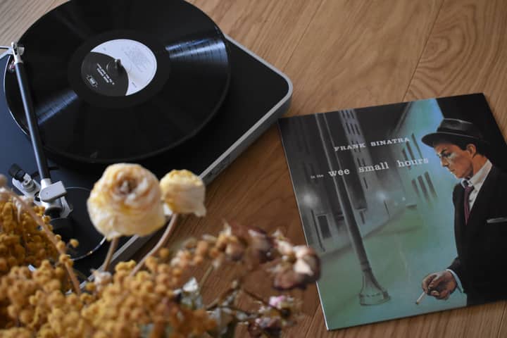 A nostalgic scene featuring a vinyl record on a turntable and Frank Sinatra's album, perfect for music lovers.