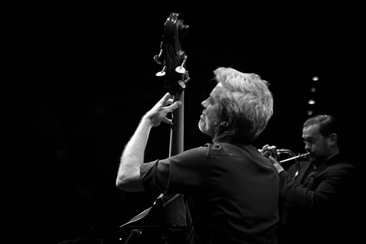 Dynamic grayscale photograph showcasing musicians playing jazz instruments on stage.