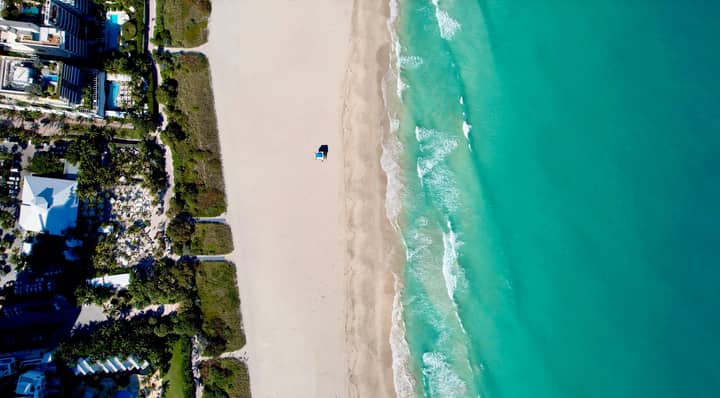 Stunning aerial view of Miami Beach's coastline, showcasing turquoise waters and sandy shorelines.