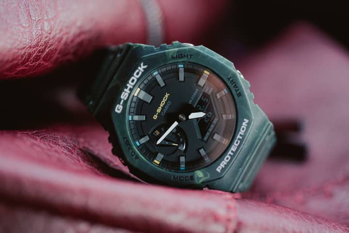 Close-up of a G-SHOCK digital wristwatch displayed on red leather.
