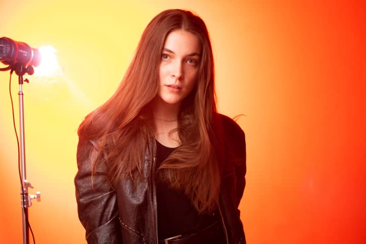 Artistic studio portrait of woman with a red background.