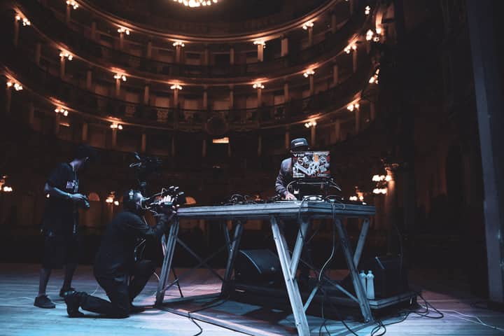 DJ performing with crew in a grand theater in Brazil, capturing the essence of live music and performance.
