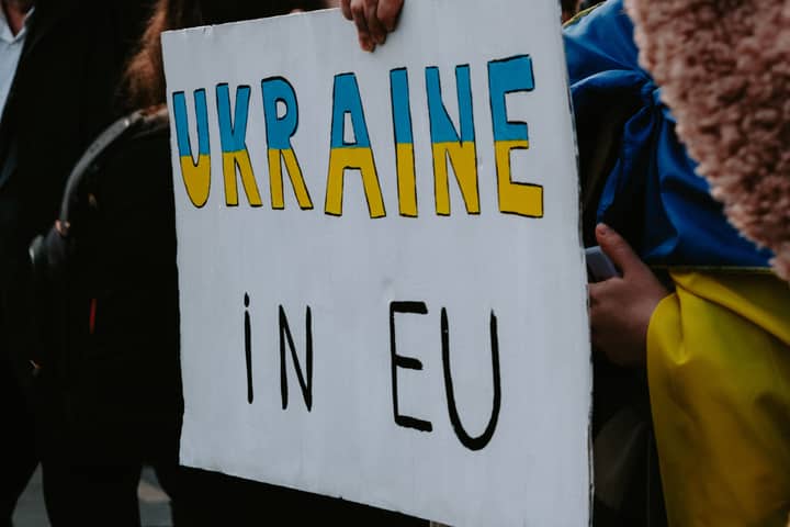A protest sign advocating Ukraine's membership in the EU, held by demonstrators outdoors.