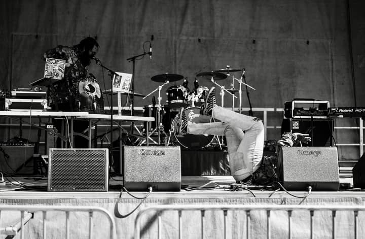 Dynamic monochrome image capturing a live stage performance with musicians and equipment.