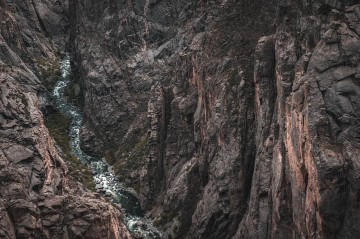 Aerial view of the rugged Black Canyon showcasing dramatic geological formations and a flowing river.