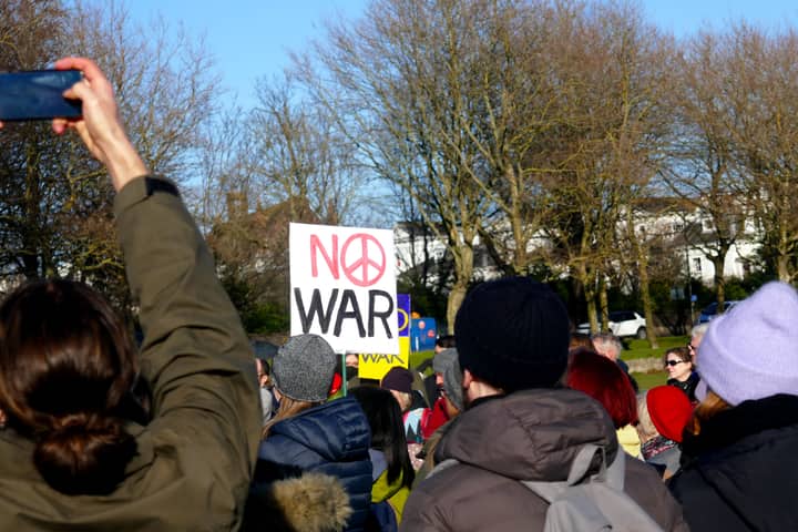 Crowd in Brighton, England, protesting against war with signs and peaceful demonstration.