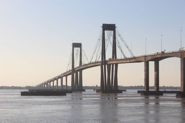 A suspension bridge over a river captured during the serene golden hour, showcasing modern infrastructure.