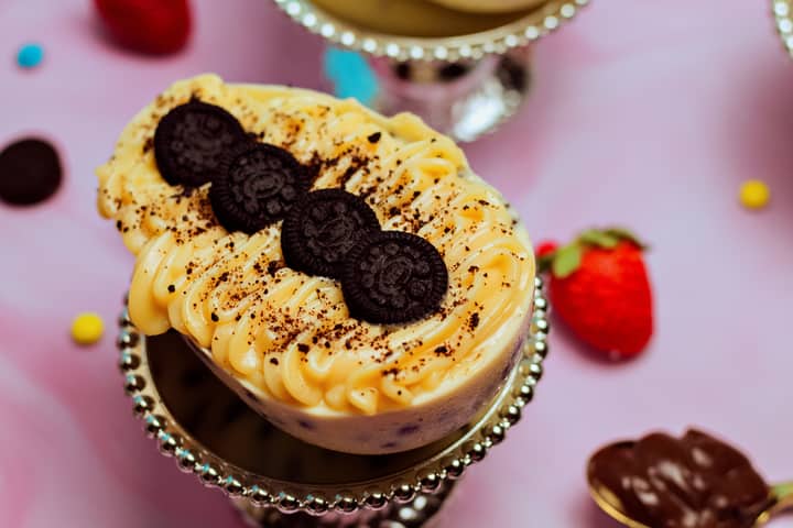 Close-up of a delicious dessert topped with mini Oreos and colorful sprinkles, perfect for any sweet tooth.