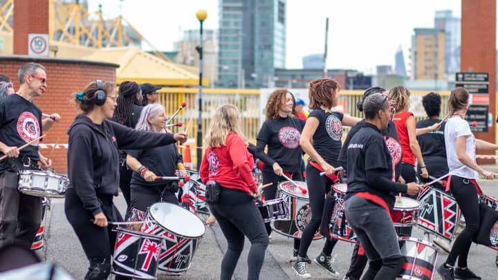 Energetic street drummers entertaining a festive crowd in London.