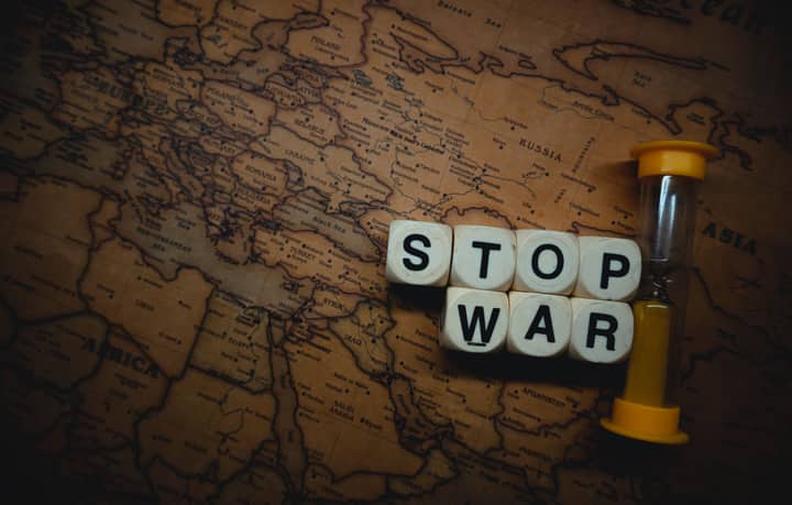 A powerful message 'Stop War' displayed on a vintage world map with an hourglass, symbolizing urgency and global issues.