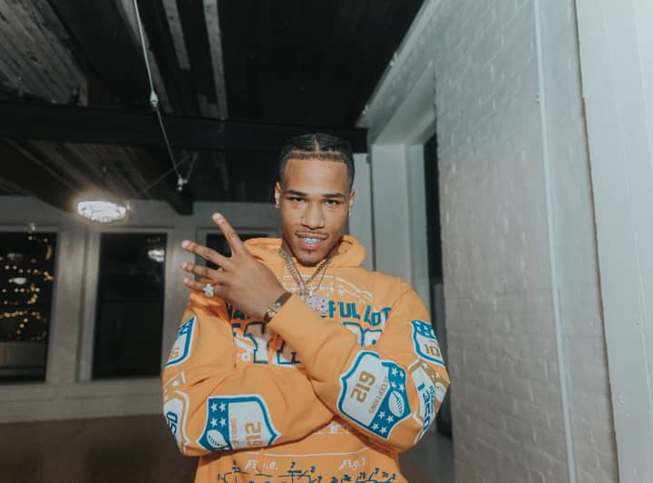 A confident man posing indoors with a stylish urban outfit in Omaha, NE.