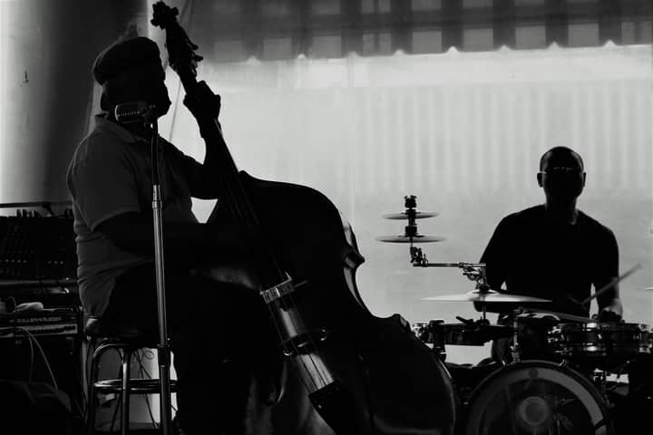 Silhouette of bass and drum musicians performing live jazz music.