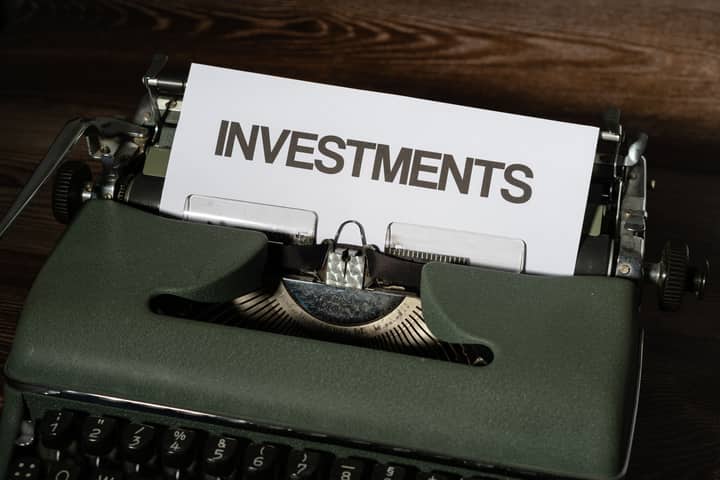 Close-up of a vintage typewriter with a paper labeled 'INVESTMENTS'.