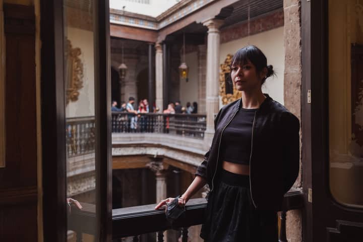 A young woman poses in a historic building, capturing the essence of cultural architecture and travel.