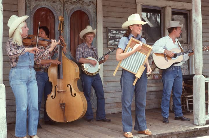 A retro country band playing music on a rustic wooden porch with various instruments.