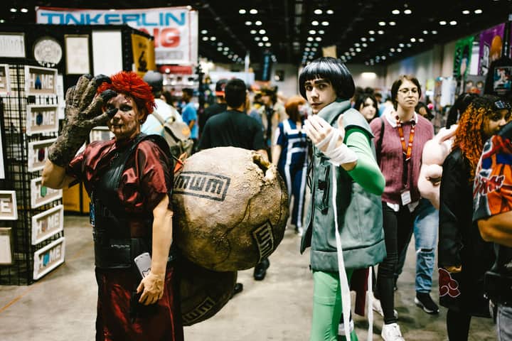 Cosplayers dressed as anime characters at a bustling convention center.