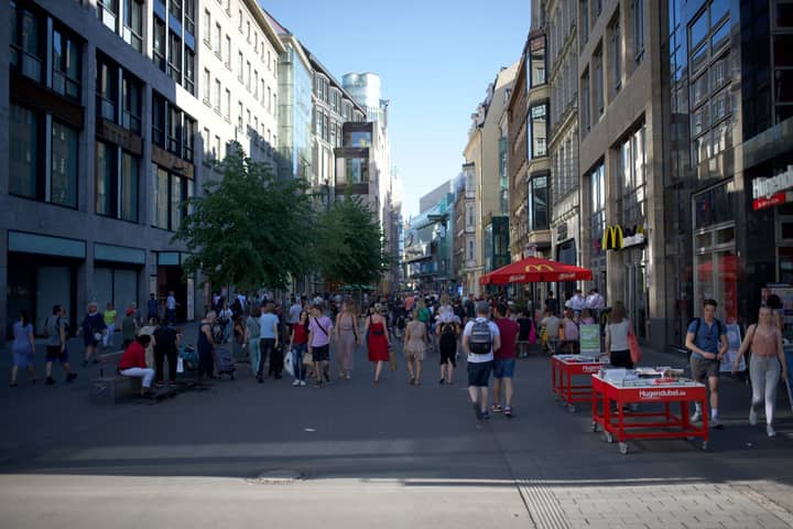 Crowded urban scene on a sunny day in Leipzig, showcasing bustling pedestrian activity.