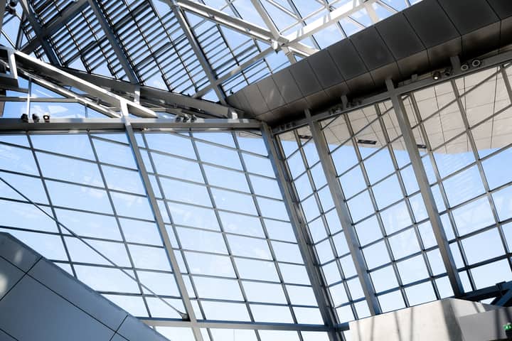 A striking view of a modern glass ceiling with metal frames and natural lighting.