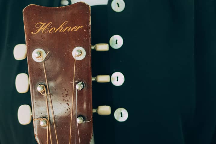 Detailed view of a Hohner guitar's wooden headstock with tuning pegs, highlighting musical craftsmanship.
