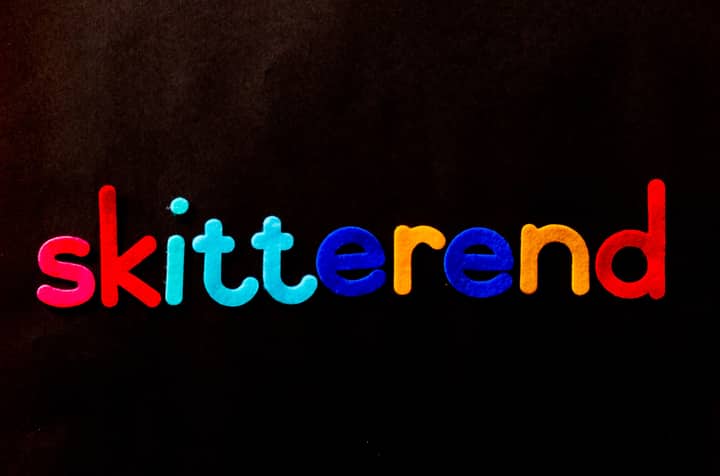 Vibrant multicolored alphabet letters spelling 'skitterend' on a dark backdrop.