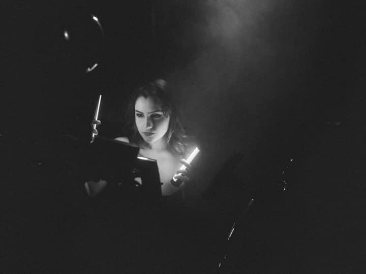 A dramatic monochrome portrait of a woman with an artistic lighting setup, creating a mysterious atmosphere.