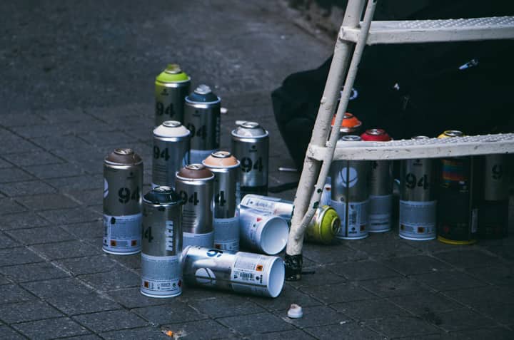 Collection of used spray paint cans and ladder on a street in Istanbul, ideal for urban art themes.